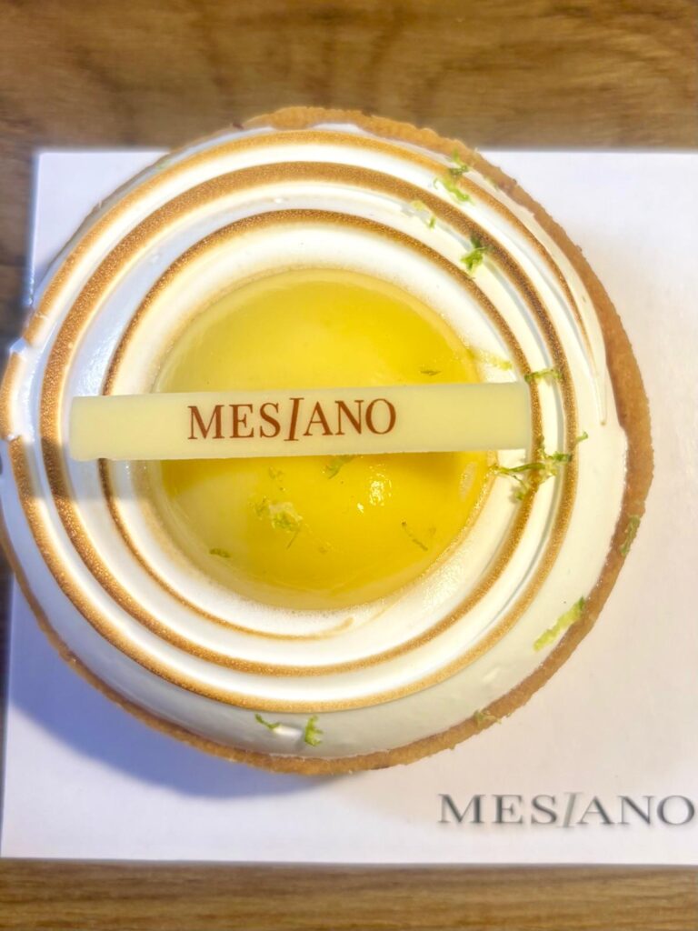 Une tarte au citron avec de la meringue en dessous et le nom mesiano écrit dessus.