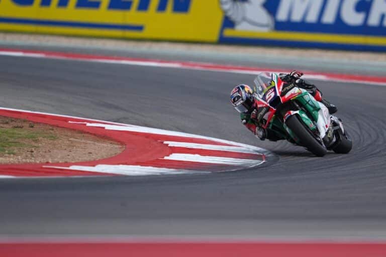 Le pilote Cannois, Johann Zarco en piste avec as Honda LCR rouge, verte et blanche en plein virage le genou proche du sol.