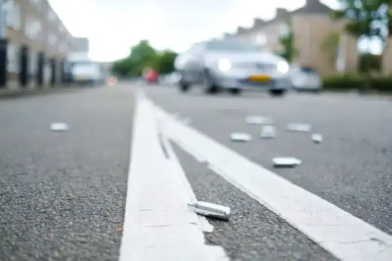 Des minis bouteilles de protoxyde d'azote sur la route.