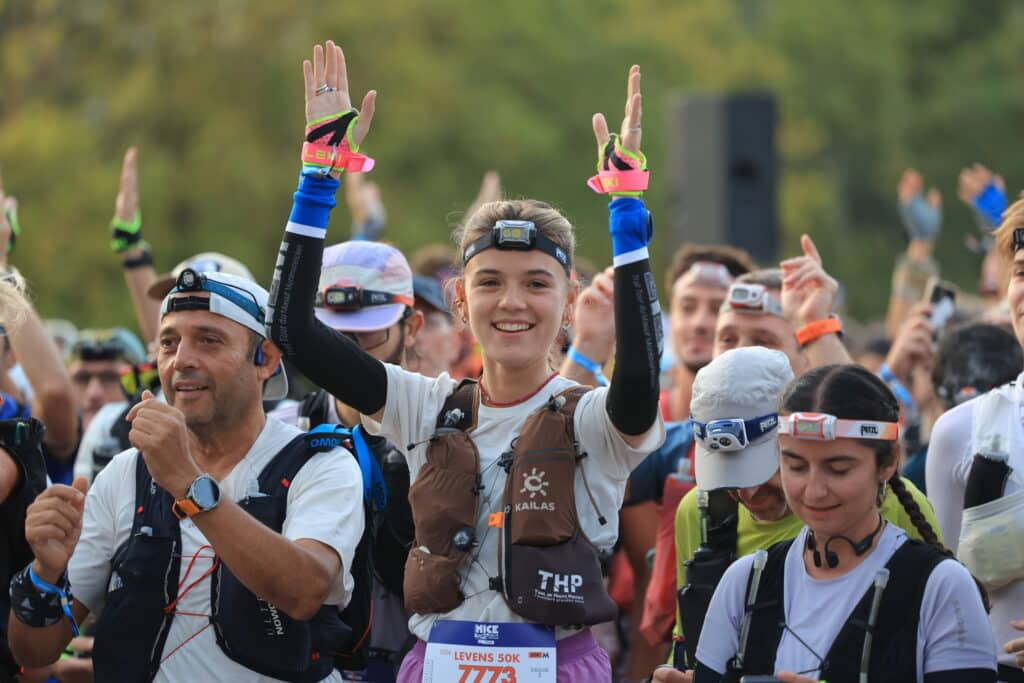 Une participante de l'UTMB Nice 2026 tape dans les mains pour mettre de l'ambiance avant le départ.