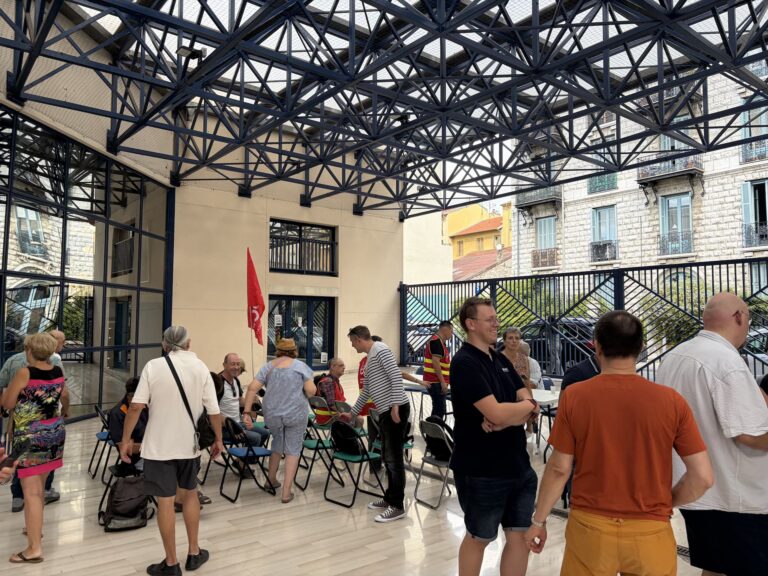 Groupe de personnes rassemblées aux Chemins de fer de Provence à Nice lors d’une grève, en présence de la CGT et du PCF 06.