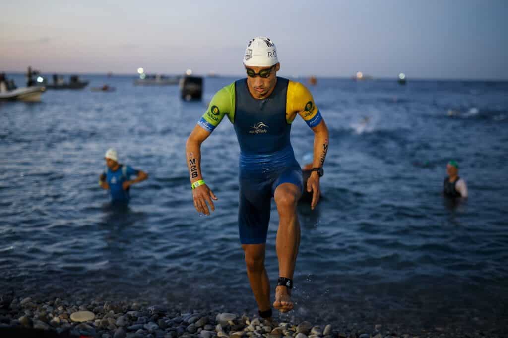 Un athlète à la course sur les galets de la Promenade des Anglais avec son bonnet de bain et ses lunette de natation.