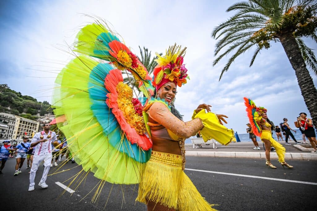 Une danseuses en costume brésilien tout en couleur fait un spectacle sur le parcours de l'Ironman de Nice