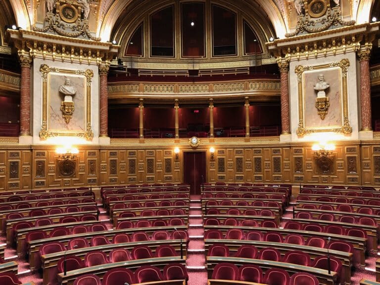 L'intérieur du Sénat avec des fauteuils en velours rouges et des dorures un peu partout dans la salle.