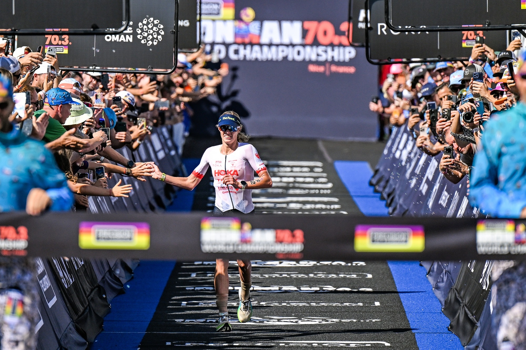 La vainqueur de l'édition 2026 du championnat du monde Ironman à l'arrivée tape dans la main des spectateurs le long du parcours.
