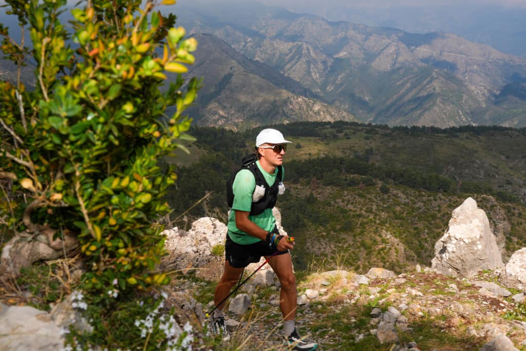 Un athlète marche dans la montagne.