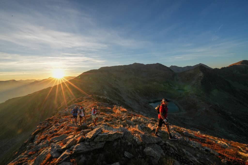 Un coucher de soleil sur les montagne avec coureurs qui passent.