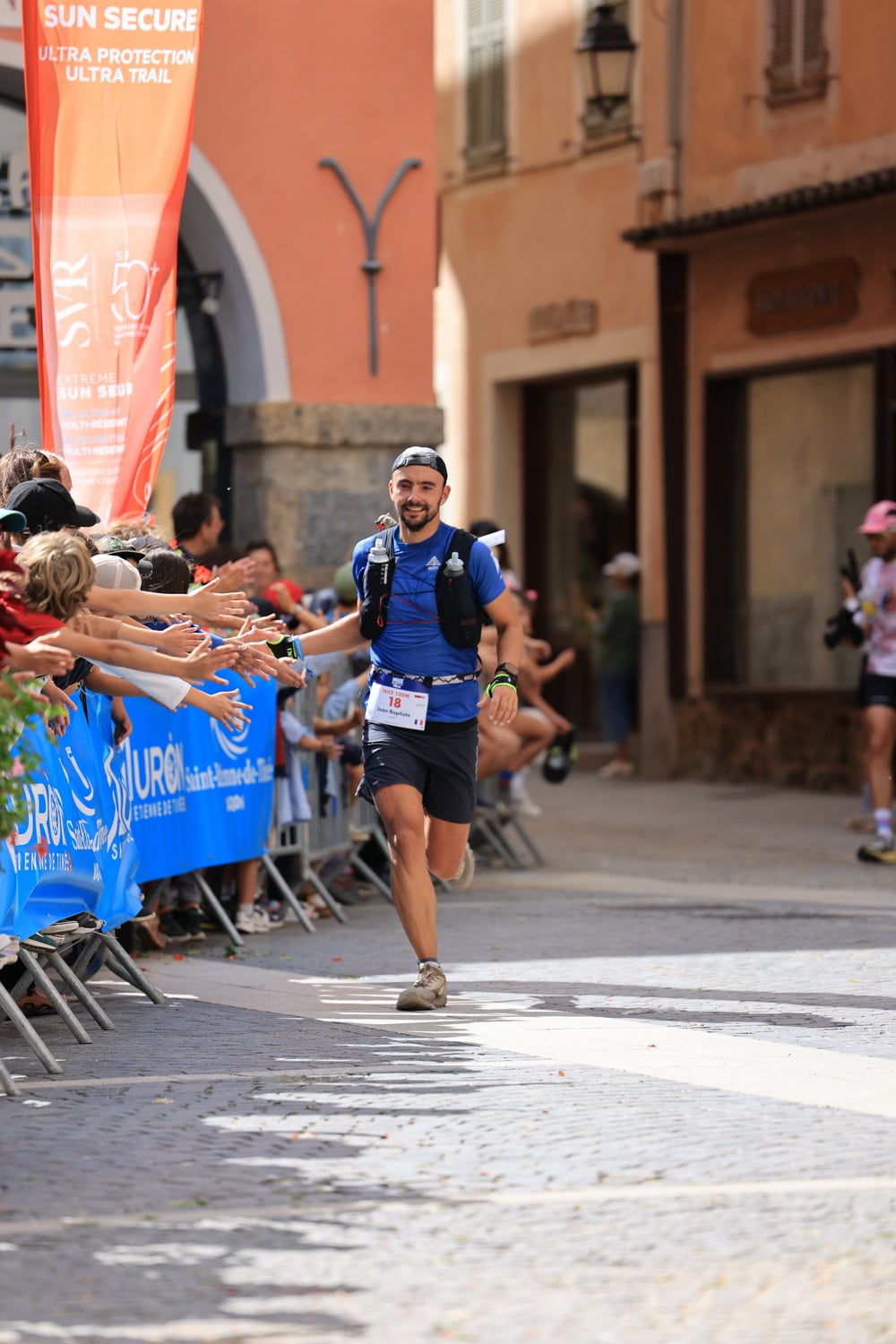 Un coureur tape dans la main des spectateurs.