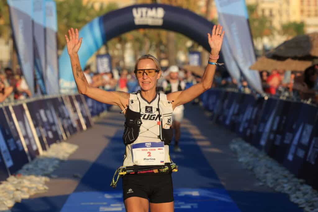 La vainqueur du 100M du Nice Côte d'Azur by UTMB Martina Klancnik Potrc lève les bras sur la ligne d'arrivée.