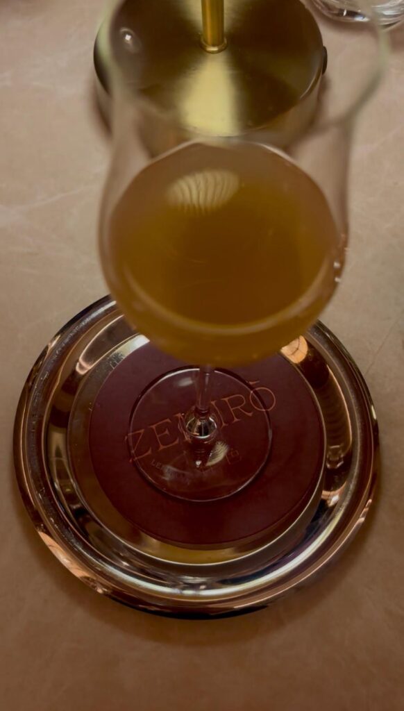 Un verre de vin posé sur une coupelle gravée Zeniro.
